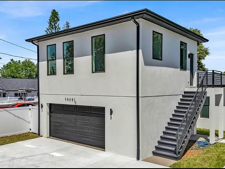 Unit is located above the garage. (Note the in-garage spaces are for the tenants of the duplex at the front of the property. Apartment tenants use the two driveway spots to the right.)