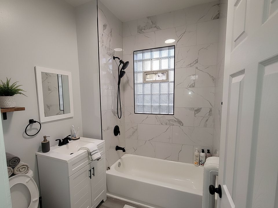 Fully remodeled bathroom with marble-style tile, modern vanity, and a shower/tub combo. Clean, stylish, and move-in ready.