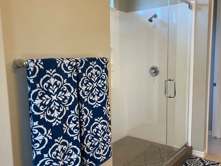 Shower seat built in behind where the towels are hanging. There is also another linen/storage closet in this bathroom.
