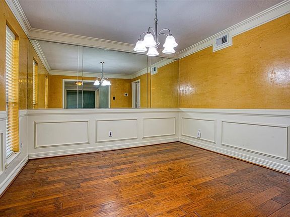 Dining Room features Wainscoting, Designer Paints and Windows for natural light, overlooking the Fully Covered Front Porch.