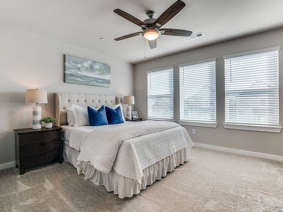 Spacious bedroom with plush carpeting and natural light
