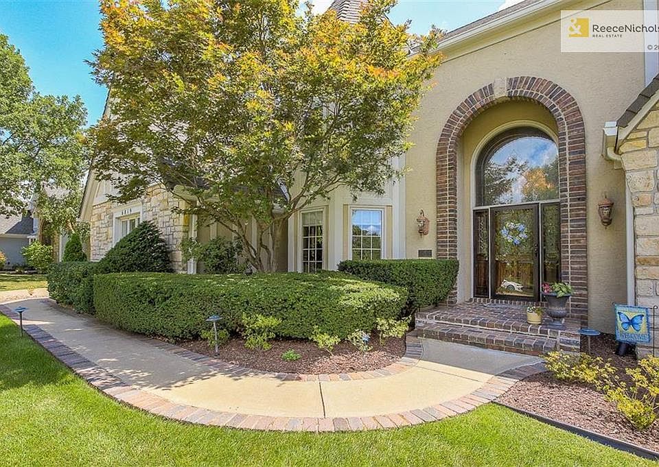 BRICK LINED SIDEWALK BRINGS YOU TO THE FRONT DOOR. STONE, STUCCO WITH BRICK TRIM