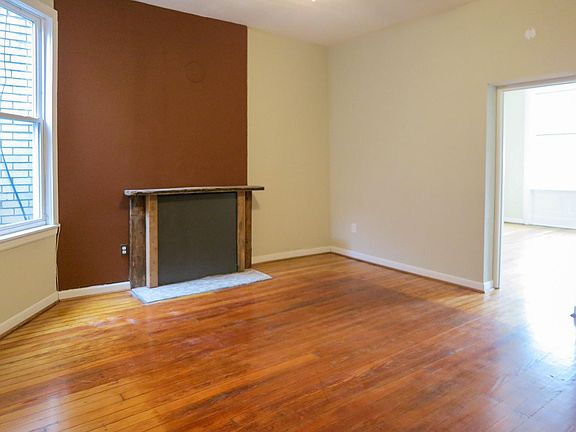 Spacious Living Room connecting to the front bedroom via pocket doors. Walls are no longer red.