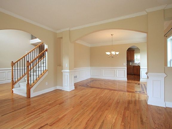 Living room opens to formal dining room and entry with arched openings.
