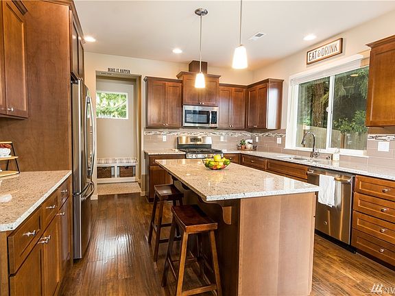 Lovely shaker style cabinets, granite counter tops with pendant lights and breakfast bar,  tiled back splash, hardwood floors, stainless steel appliances. Don't miss the mud room and walk-in pantry!