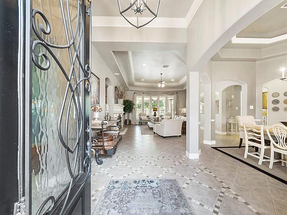 The wood and obscure, privacy glass with decorative wrought iron detailing invites you in to this stunningly elegant home.