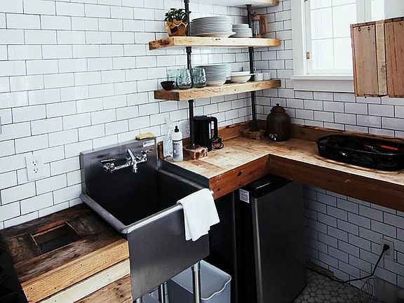 Kitchen has stainless steel commercial sink and 4 burner stove/oven