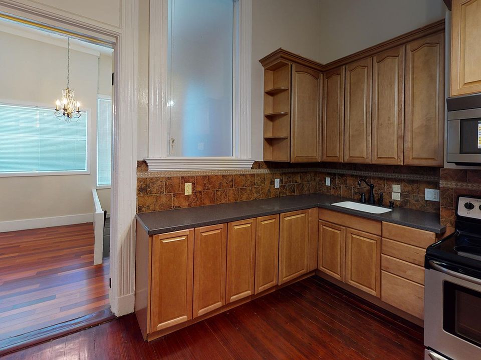 PICTURE IS OF KITCHEN WITH TONS OF BEAUTIFUL MAPLE CABINETS AND CROWN MOLDING. BACK VIEW IS TO THE FAR BACK BEDROOM THAT OVERLOOKS HUGE SHARED YARD ON THE RIGHT SIDE OF THAT BEDROOM IS A STAIR LEADING TO THE BACK YARD AND HUGE SHARED LAUNDRY ROOM DIRECTL