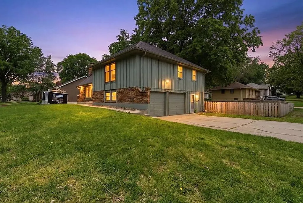 Stunning evening view highlighting the home's warm lighting, spacious layout, and quiet residential setting ideal for families, groups, and extended stay guests. - 1100 SW Mic O Say Dr