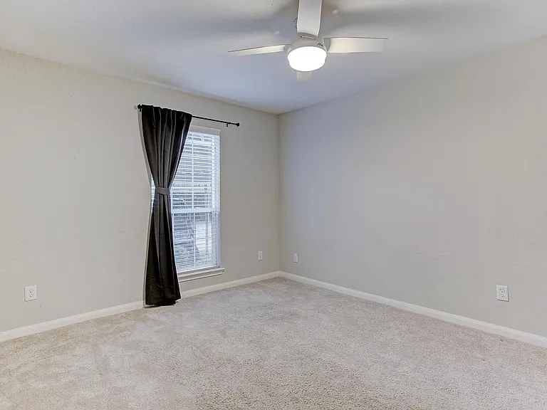 Large bedroom with brand new remote-control fan and walk-in closet - view without furniture.