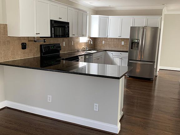 Kitchen with granite countertops, stainless steel fridge and dishwasher