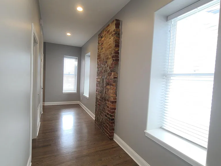 Original 1859 Brick wall in the hallway.
Beautiful Red Oak hardwood floors throughout condo.