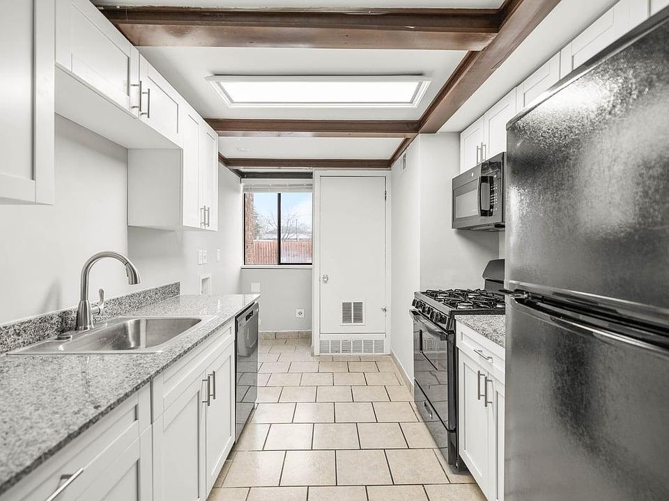 Renovated gally style kitchen with window, NEW cabinets + appliances, dishwasher, W/D hook-up, tile floor & utility closet.