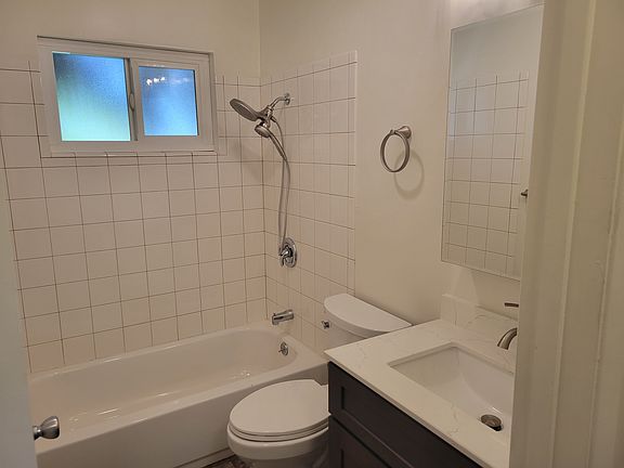 Remodeled bathroom includes quartz vanity.