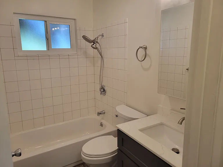 Remodeled bathroom includes quartz vanity.