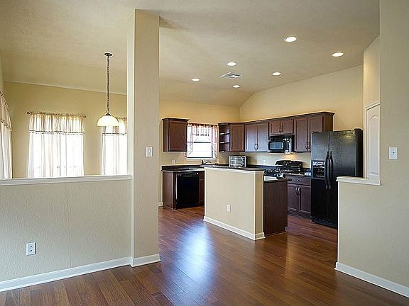 Open to the living room and breakfast area, the kitchen features plentiful counter space and recessed lighting.