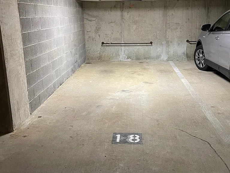 Full Size Corner Garage Parking Space w/ New Overhead Lighting and Bar for Bike Storage.