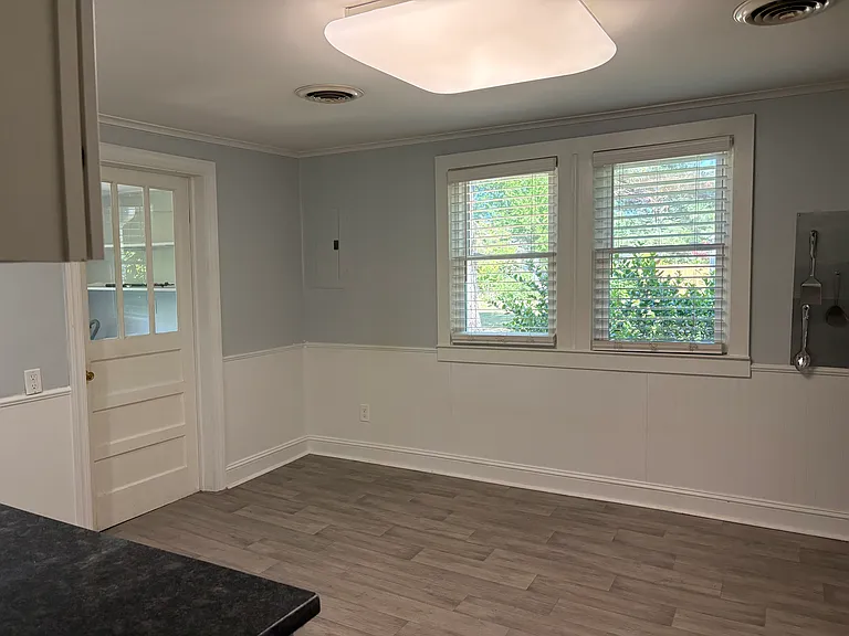 Different view of kitchen showing door to laundry room.