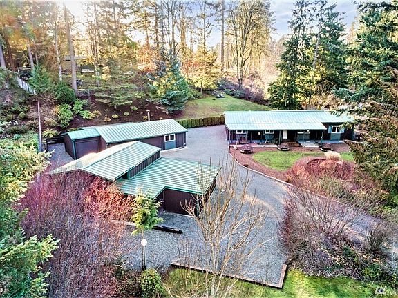 View from front of property that shows taller garage (RV parking) and additional enclosed parking for riding lawnmower in the front of building