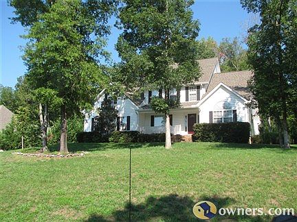 Front of two story home surrounded by trees