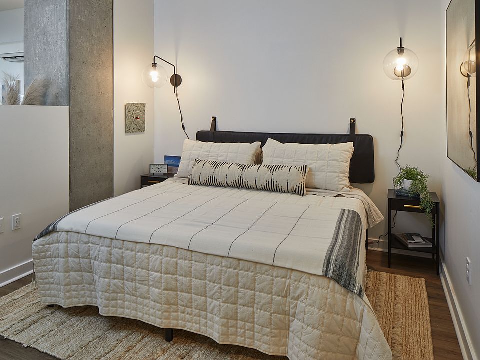 Spacious apartment bedroom with wood-style flooring.