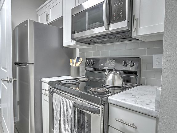 Kitchens with stylish appliances and a hip grey tile backsplash.
