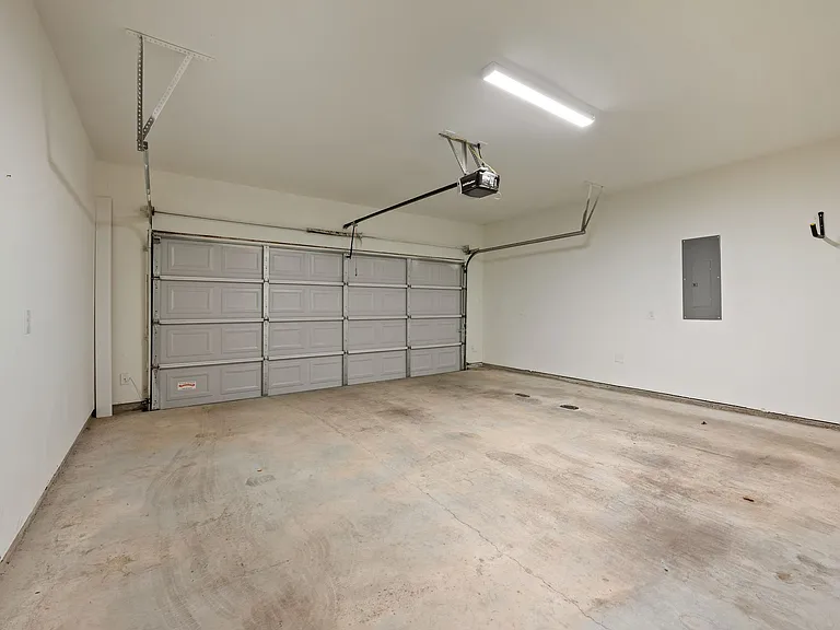Over-sized, clean two-car garage with built-in bicycle racks. View from door to entry into first floor door.