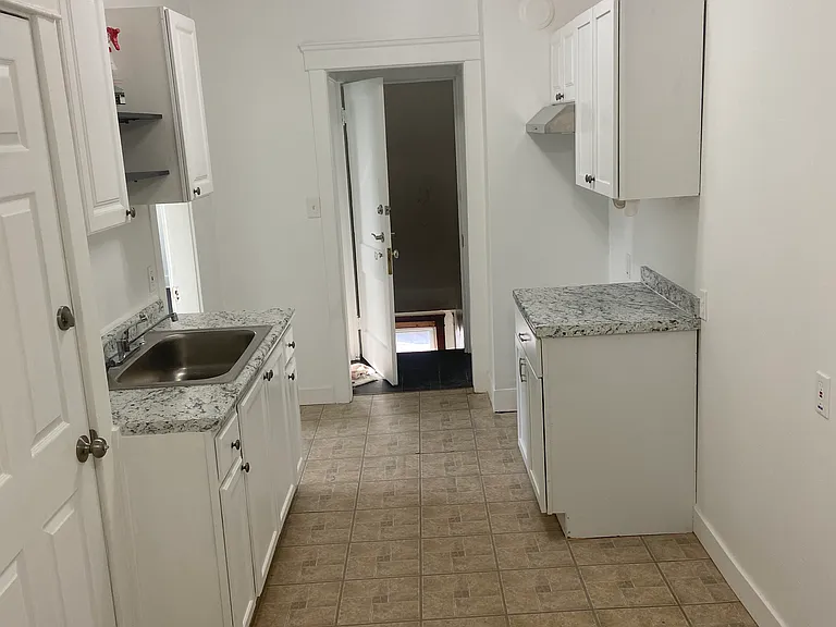 Large kitchen with eat-in area and back stairway to basement and side exit. No access to attic.