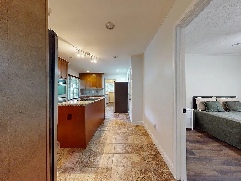 Galley-style kitchen with granite counters, generous cabinetry, and a peninsula for prep or casual dining, near the bedroom.