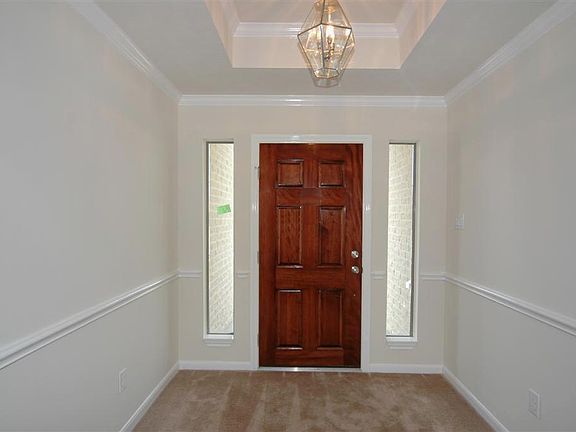 inviting entry with trey ceiling, crown molding and chair rail.