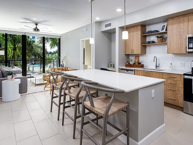Open concept kitchen with quartz countertop, island, stainless steel appliances and tile backsplash