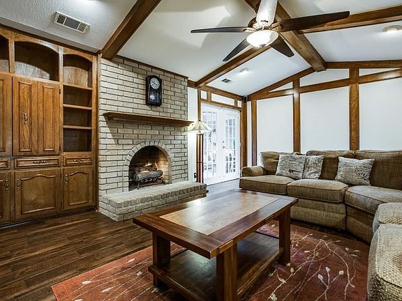 Living room has gas logs and double doors entering the covered patio room.