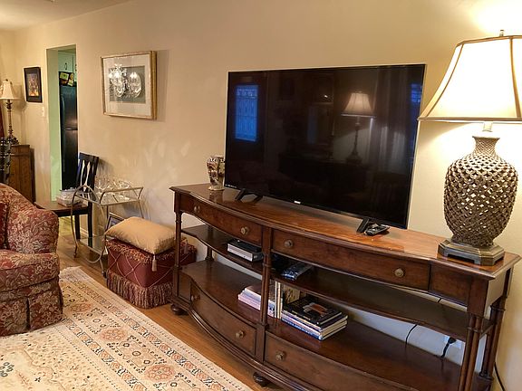 50" Smart TV in living room with DVD player, book & DVD collection.