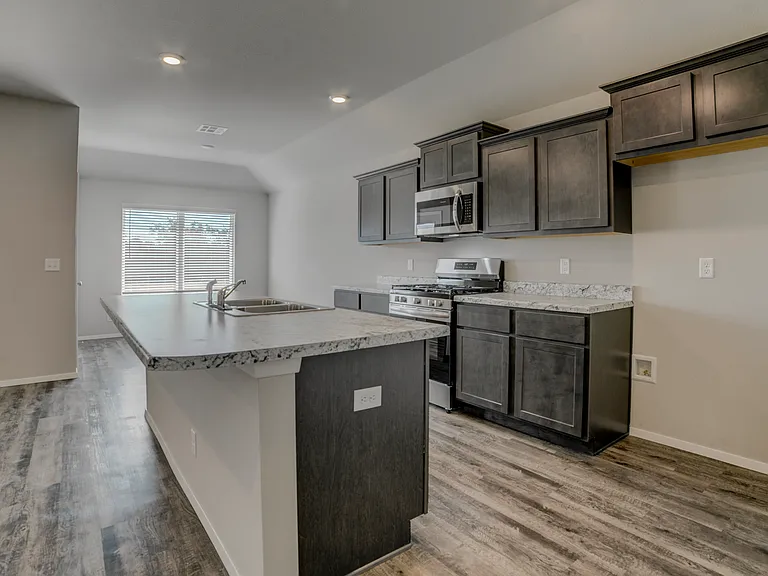 Not pictured is the included refrigerator. To the right is the walk-in pantry and further to the right is the laundry room.
