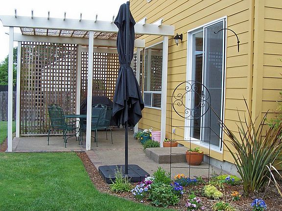 Back Patio shaded with sweet pea covered lattice and bamboo reeds