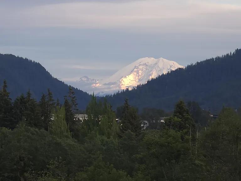 6.7.2026 -Master bedroom window view of Ranier mountain with the sun shining on it.