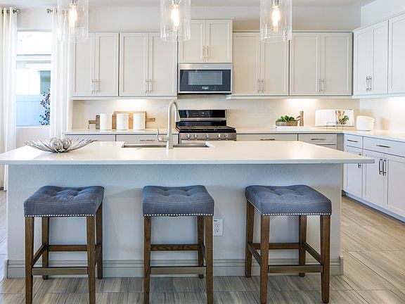 The kitchen island offers additional seating and can be used as a breakfast nook for busy mornings