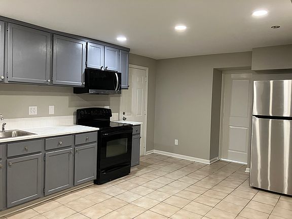 Large kitchen w/ new canned lighting , countertop, sink, microwave & refrigerator. There is room for dining set.