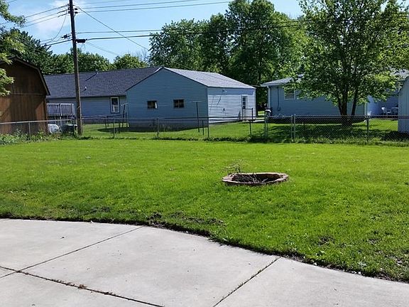 Wonderful fully fenced back yard with concrete patio, built-in fire pit, and lots of space for outdoor FUN!