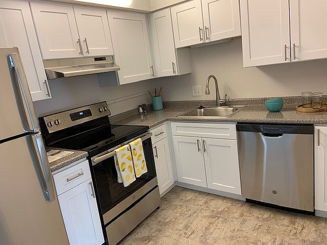 Updated Kitchen With Stainless Appliances, White Cabinets, Neutral Formica Counters And Floors