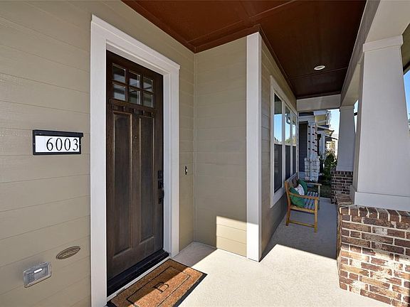 Front porch elevation is classic. Front porches evoke eras of friendly neighborhoods with people waving, welcoming and visiting each other. Notice the craftsman front door with divided light window insert.