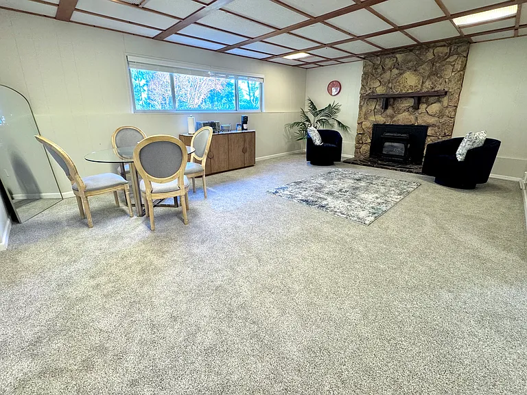 lower level living area with gas furnace and new carpet