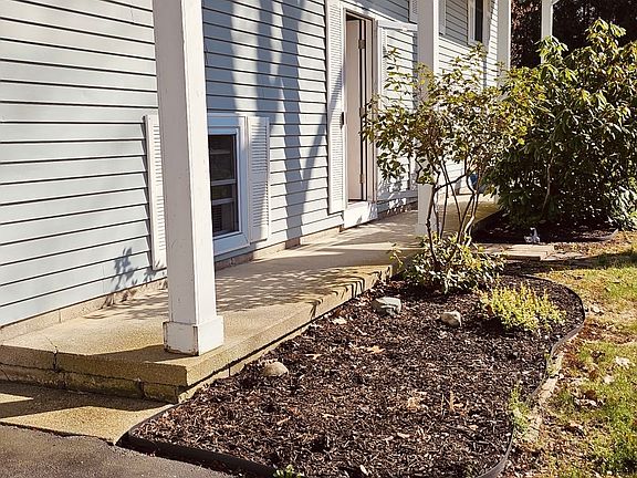 The front of the home is framed by lovely magnolia bushes and a spacious garden bed, ideal for planting colorful annuals each season_fun for families who enjoy gardening