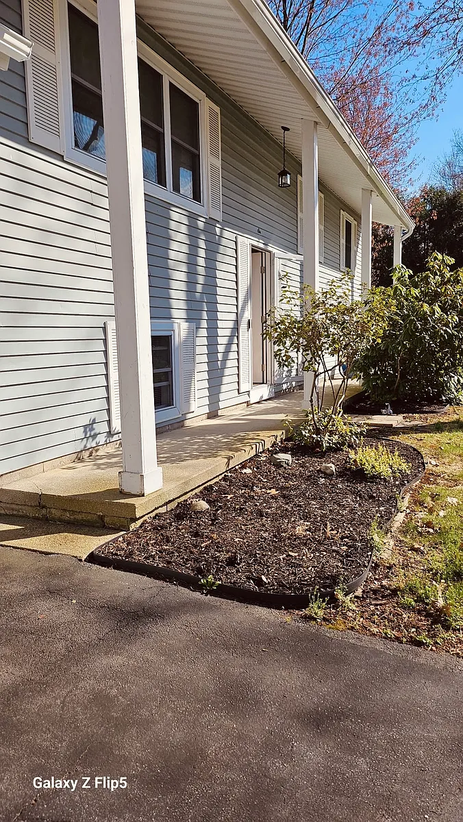 The front of the home is framed by lovely magnolia bushes and a spacious garden bed, ideal for planting colorful annuals each season_fun for families who enjoy gardening - 6 Mohegan Ct
