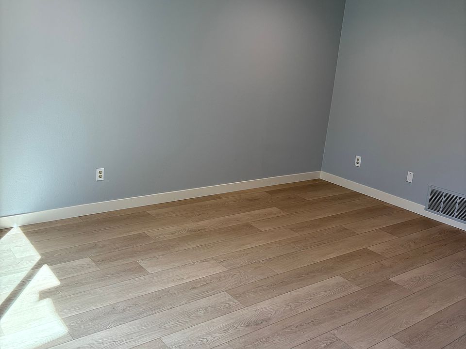 Spacious modern living room with recessed lighting and new vinyl flooring