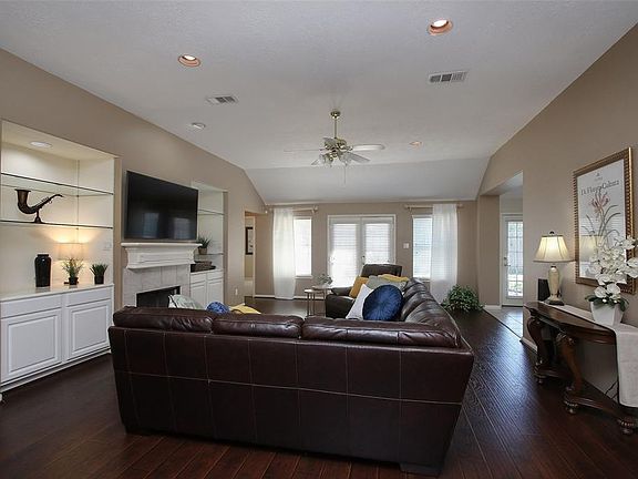 Large family room w/ lighted showcase shelving and cabinetry frames the gas fireplace and mantle. This family room is center of the home for easy entertaining and constant family interaction.