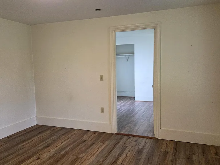 View From Living Room Into Bedroom Both Rooms With Premium Laminate Flooring.