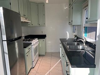 Other side of the kitchen. There is a door that leads to the backyard from the kitchen at the far right.