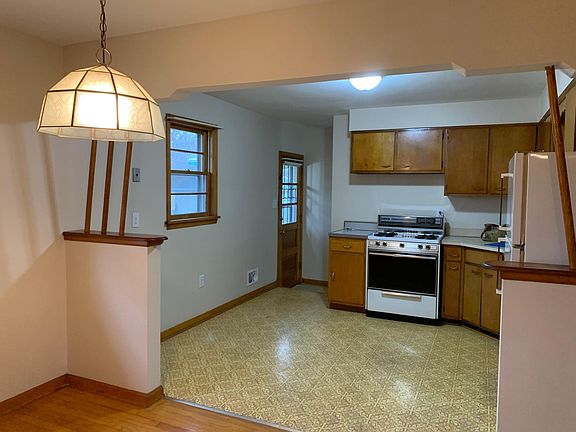 Retro kitchen next to large dining area and access to backyard.