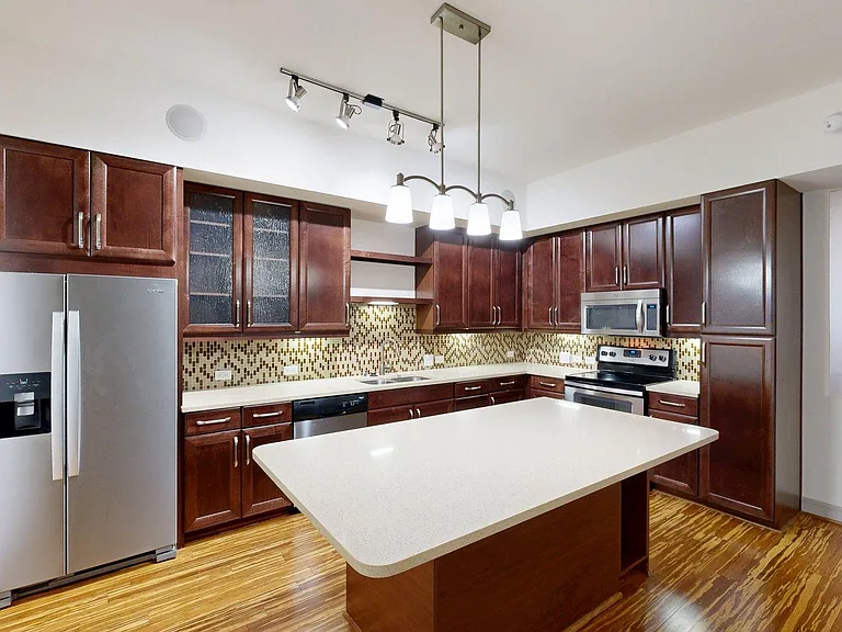 Apartment Kitchen with Quartz counter tops and Wood-Style Flooring.